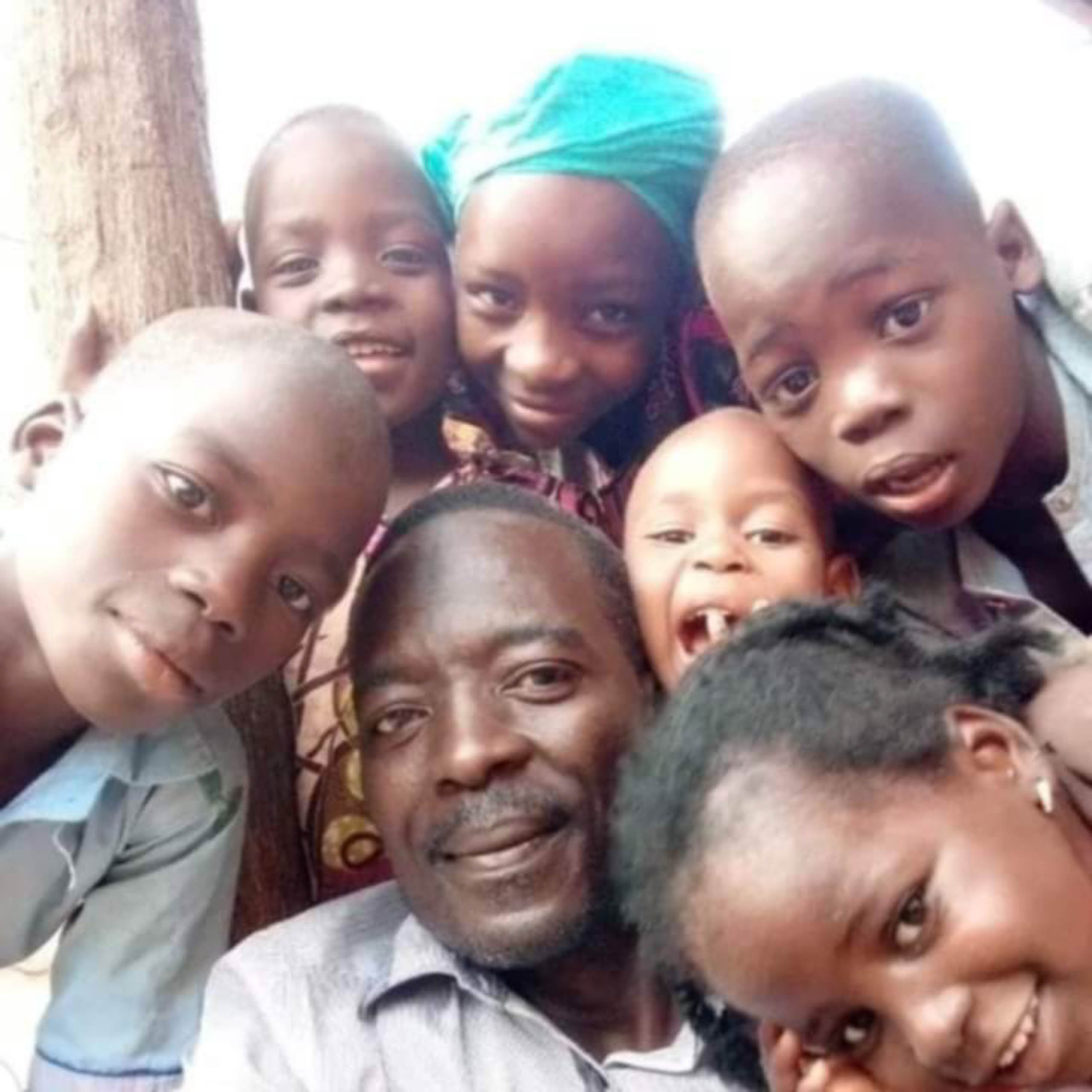 Mourtala Issa lacht gemeinsam mit sechs Kindern in die Kamera, Zinder, Niger · Projekt #waterforzinder